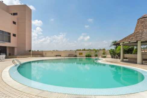 Swimming pool at Malacca River Aparthotel with clear water and sunny sky.