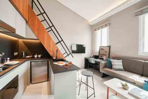 Apt interior with kitchen, sofa, and workspace in a Singapore Jalan Besar Aparthotel.
