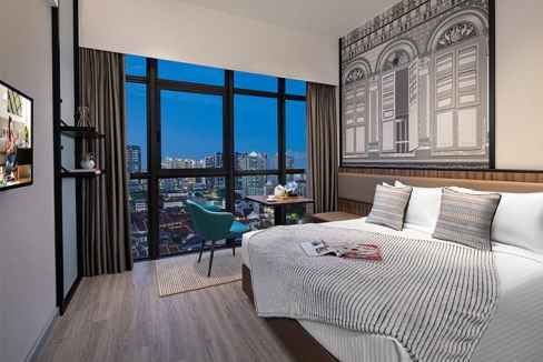 Aptly designed hotel room in Singapore Rochor with large windows and contemporary furnishings.