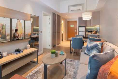 Aparthotel Manila Quezon City living room with contemporary furniture and city skyline view.