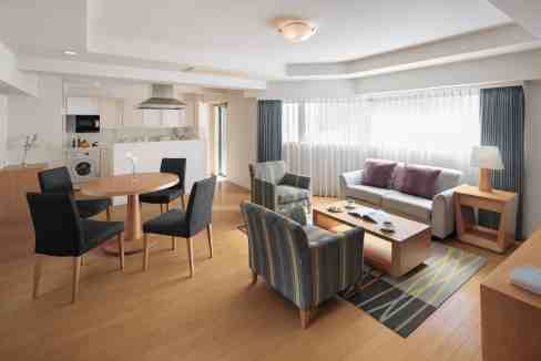 Spacious living area at Tokyo Azabujyuban Aparthotel featuring contemporary furniture and large wind.