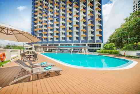 Pool area at Kuala Lumpur Damai Aparthotel with modern high-rise building backdrop.