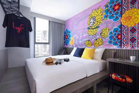 Contemporary hotel room at Bangkok Sukhumvit Nana Aparthotel featuring colorful wall art and modern.