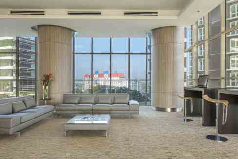Spacious hotel lobby featuring contemporary furniture and panoramic cityscape views at Iskandar Pute.