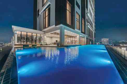 Night view of Cebu Capitol Site Aparthotel with illuminated rooftop infinity pool.