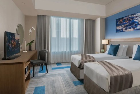 Apt hotel room with two beds, ocean view, and contemporary decor at Manila Bay City Aparthotel.