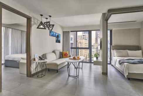 Spacious living area in Singapore Orchard Aparthotel featuring contemporary furniture and large wind.