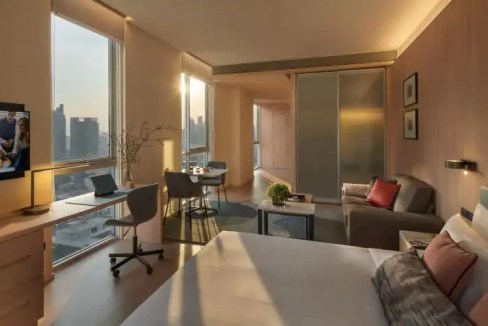 Bright, spacious hotel room in Bangkok Sukhumvit 55 with large windows and stylish furnishings.