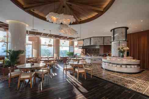 Elegant hotel restaurant with stylish decor, wooden accents, and large windows.