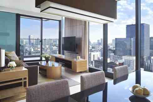 A spacious living area with floor-to-ceiling windows offering city views at Tokyo Station Aparthotel.