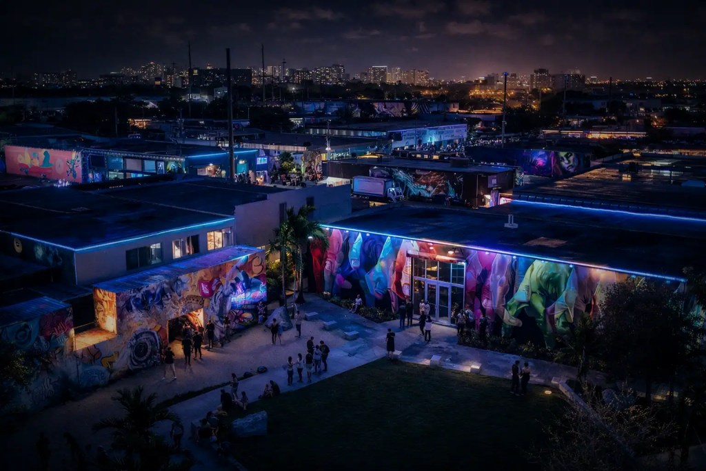 Vibrant Miami Heat-themed mural art illuminated at night in an outdoor urban setting.