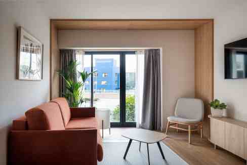 Contemporary living room with large window, sofa, and minimalist decor.