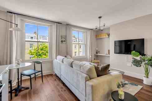 Bright living room with large windows, white walls, and contemporary furniture.