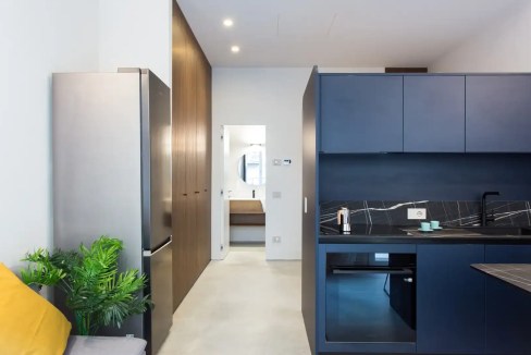 Modern blue kitchen featuring sleek cabinetry and black countertops. Bright, clean, and contemporary.