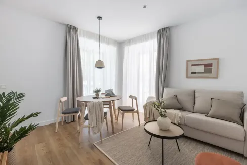 Bright living room with dining space, large windows, and minimalist decor.
