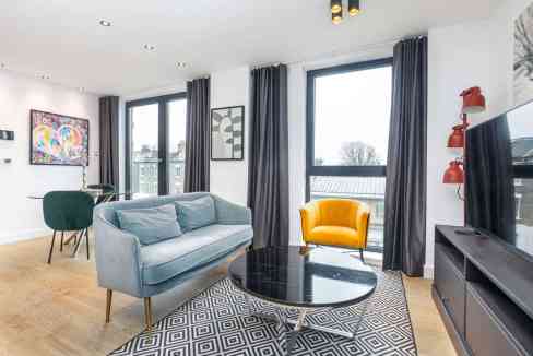 Bright and airy living room featuring a blue sofa, yellow armchair, and contemporary decor.