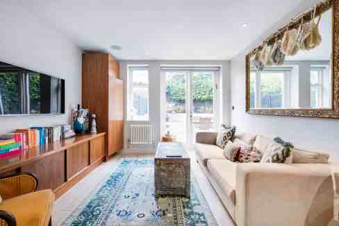 Living room with large windows, stylish furniture, and decorative accents for a cozy, contemporary s.
