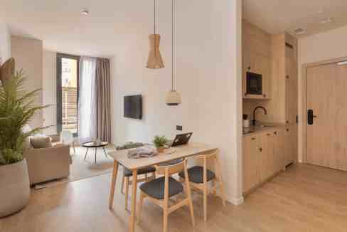 Bright modern living and dining area with natural light and minimalist decor.