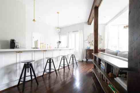 Bright Pasadena Spanish Retreat kitchen with white cabinets, wooden accents, and natural light.