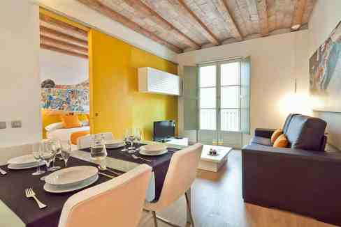 Bright living and dining room with colorful accents, large windows, and contemporary furniture.