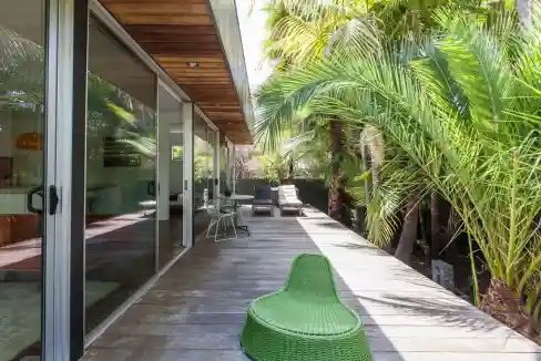 Outdoor lounge area at Venice Eco Retreat with lush tropical plants and modern seating.