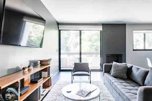 Bright, spacious living room featuring large windows, contemporary furniture, and a cozy atmosphere.