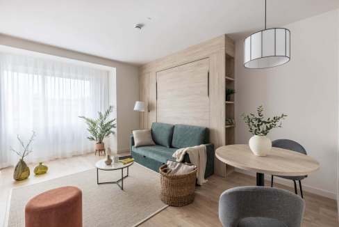 Bright and airy living room featuring minimalist decor, neutral tones, and natural light from large.