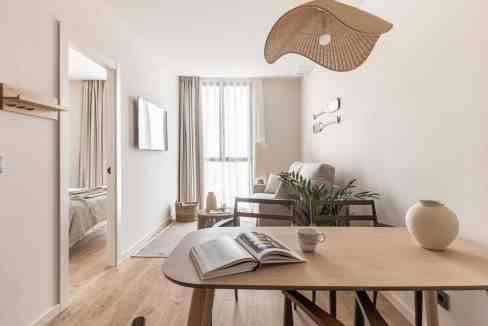 Living room with minimalist design, natural light, and cozy decor elements for a relaxing atmosphere.