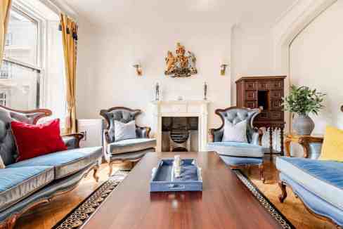 Elegant living room featuring vintage furniture, a fireplace, and decorative accents for a sophistic.