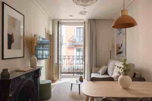 Bright and airy living room with balcony, stylish decor, and natural light in Paris apartment.