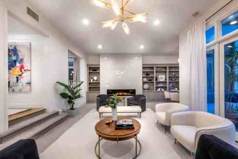 Stylish living room interior featuring comfortable sofas, contemporary lighting, and decorative shel.