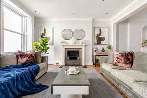 Elegant living room with stylish furniture, mirrors, and decorative accents.