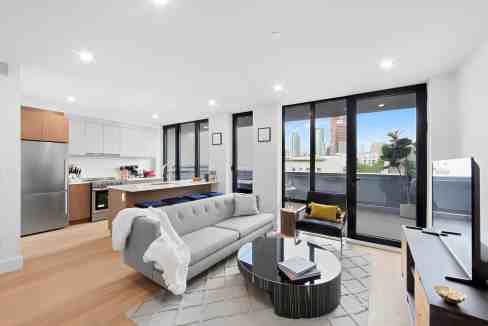 Spacious living room featuring large windows, contemporary furniture, and cityscape views in Greenpo.