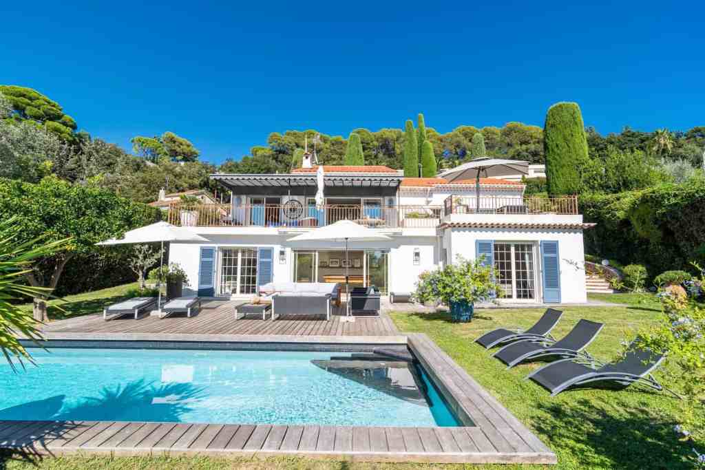 Luxury villa with pool, outdoor seating, and vibrant greenery in California.