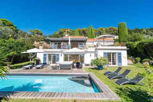Luxury villa with pool, outdoor seating, and vibrant greenery in California.