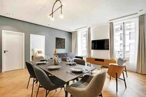 Contemporary dining and living room with elegant furniture and natural light.