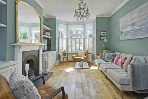 Bright living room with bay windows, stylish furniture, and decorative accents.