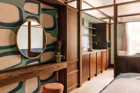 Stylish interior of a serviced apartment with wooden accents and decorative wallpaper.