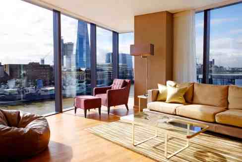 Modern living room with panoramic city views from floor-to-ceiling windows.