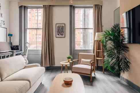 Modern living room in City Road Loft with large windows and stylish decor.