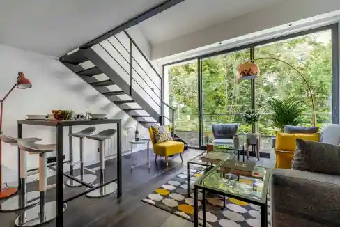 Modern living room with large windows and stylish furniture in Paris Greenlight Loft.