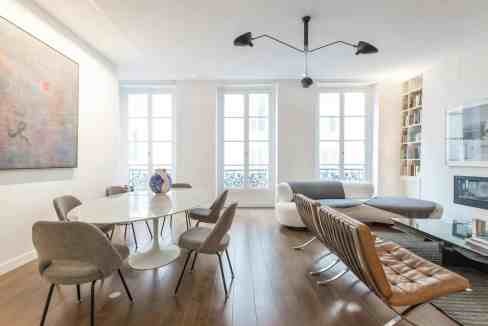 Bright living room with large windows, contemporary furniture, and artwork.