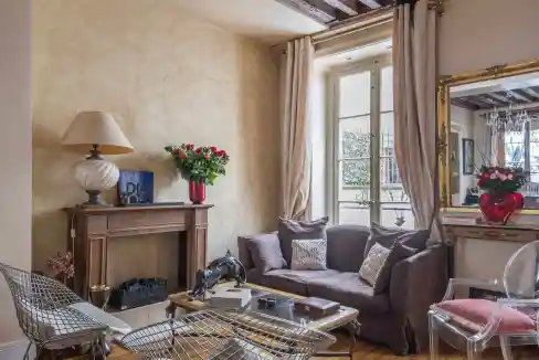Cozy living room with large window, elegant furniture, and decorative accents.