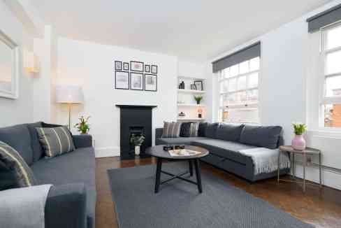 Spacious living room with sofas, coffee table, and large windows in a serviced apartment.