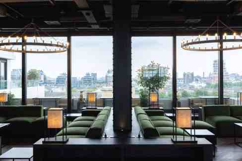 Elegant modern lounge interior with large windows overlooking a cityscape. Comfortable seating and a.