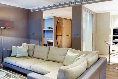 Spacious living room with beige sofa and contemporary decor.