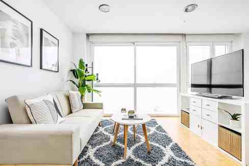 Bright living room with large windows, white walls, and contemporary furniture.