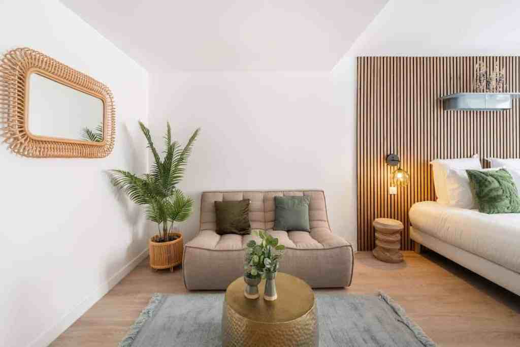 Modern living room with beige sofa, green cushions, and wooden accents.