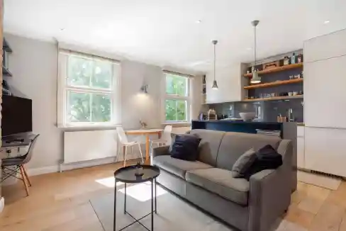 Bright and airy living room in a serviced apartment with large windows and contemporary decor.