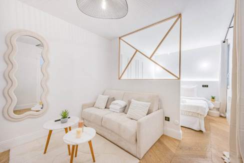 Modern living room with beige sofa and geometric wall art in Saint-Honoré Suite.